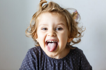 Cheerful smile child. Girl laughs close-up of the face on a white background. little girl show...