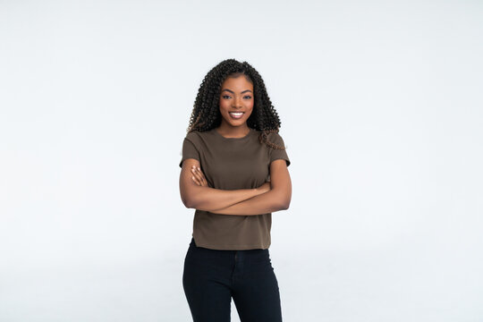 Joyful African student keeps hands crossed, isolated over white background.