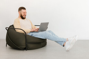 Man Using Laptop Making Video Call Sitting Indoor, Side View