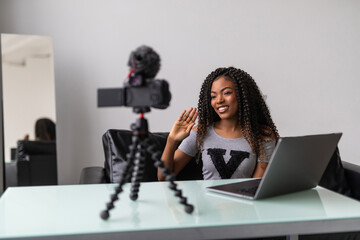 Young black woman working as blogger, recording video tutorial for Internet