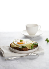 Cup of coffee, toast and egg on a white table