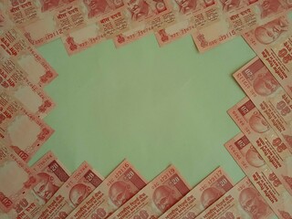 Patterned twenty rupees notes frame on a green background. Cash frame for money related businesses and content. 