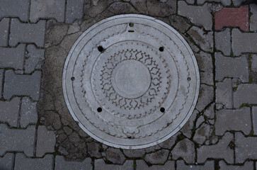 Obraz premium White sewer manhole on street.