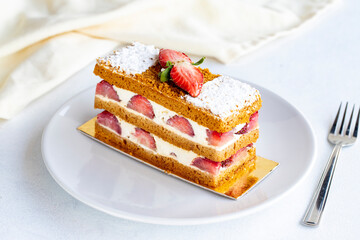 Strawberry cake slice on a white background. Layered cake with cream and strawberry. close up