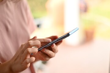 close-up woman uses modern phone flipping through news feed at home. to write a message. selective focus