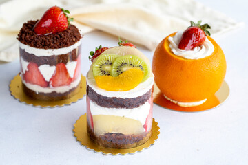 Assorted mini cakes with fruit on a white background. close up