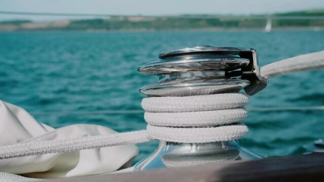 Man winds a sheet around a windlass on a sailing boat - 50fps - 4K