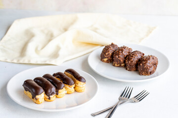 Chocolate petit four and chocolate eclair cake on a white background. close up