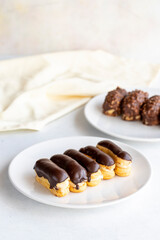 Chocolate petit four and chocolate eclair cake on a white background. close up