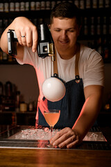 view of bubble with smoke above glass with cocktail and bartender with flavour blaster