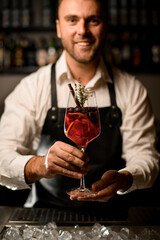beautiful glass with delicious exclusive cocktail in the hands of a male bartender