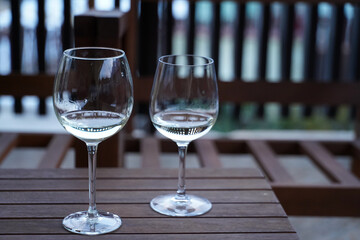 wine glasses. two glasses of wine placed on a wooden table. detail.