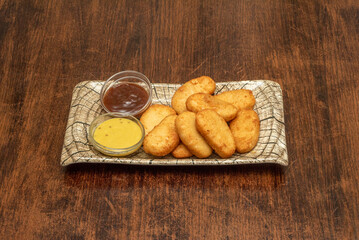 Tray of chicken nuggets with sauces served as appetizers