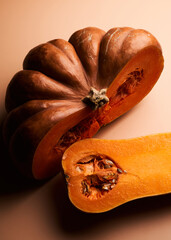 Two different sliced ripe pumpkin closeup orange background
