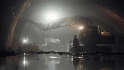 Dnipro, Ukraine - August 27, 2021: Large tracked excavator with pneumatic hammer breaks rocks during tunnel construction 