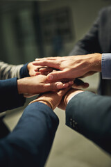 Come on team. Closeup shot of a group of unrecognizable businesspeople joining their hands together in a huddle.