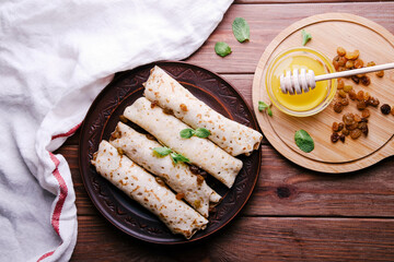 Pancakes with cottage cheese, raisins and honey on a wooden background