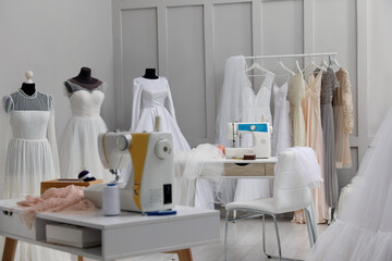 Dressmaking workshop interior with wedding dresses and equipment