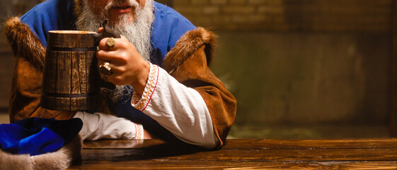 wooden mug in hand. Ancient old wooden handmade mug . Wooden beer pint