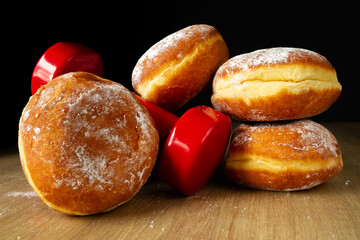 Dumbbells and Polish pączki deep-fried doughnuts. Fat Thursday (Tłusty czwartek). Pączek, traditional feast day in Poland. Healthy fitness gym workout, cheat day temptation vs sticking to diet.