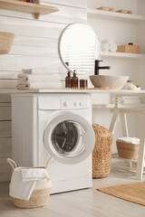 Stylish bathroom interior with modern washing machine