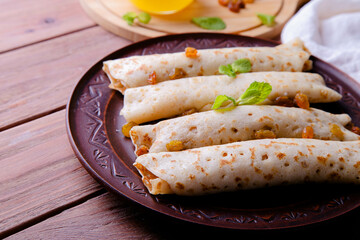 Pancakes with cottage cheese, raisins and honey on a wooden background