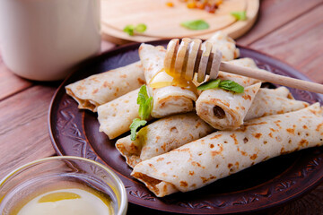 Pancakes with cottage cheese, raisins and honey on a wooden background
