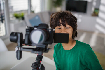 Happy multiracial boy cameraman amateur at home.