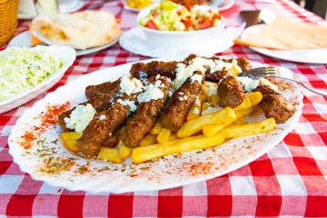 Bees fly near wooden hives taken out to a sunny meadow in the forest.