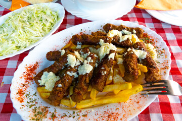 Bees fly near wooden hives taken out to a sunny meadow in the forest.