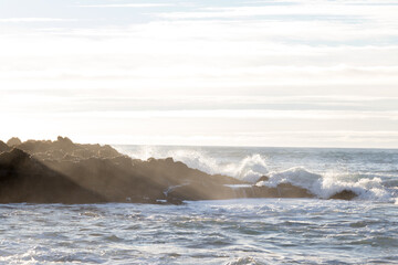 waves hitting rocks on the shore and beach