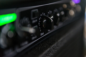Close-up of the knob that controls the bass sound of a musical amp. Part of it appears out of focus - obrazy, fototapety, plakaty