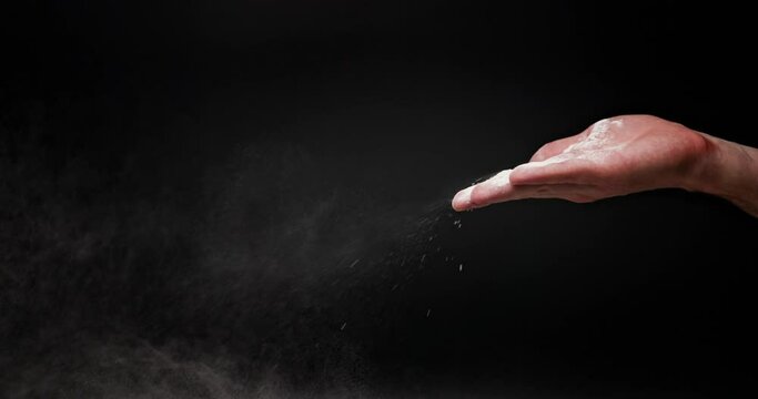 White flour powder flying against dark background
