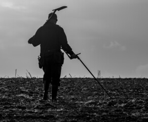 Metal detectorist with a spade over the shoulder
