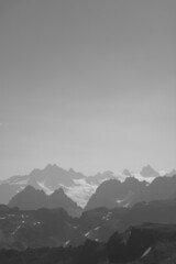 Vertical grayscale shot of snowy mountain peaks