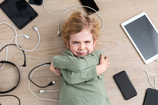 Crying boy amidst various gadgets