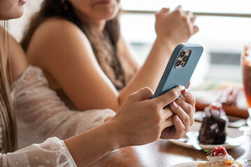 Manos de mujeres desconocidas sujetando un móvil