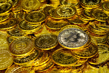 Golden bitcoin cryptocurrency on pile gold coins a lot of