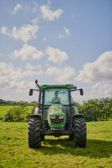 Every farmer needs one. Full length shot of a green tractor on an open piece of farmland.