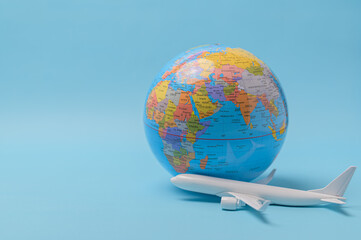 Airplane and globe isolated on blue background with copy space - travel concept