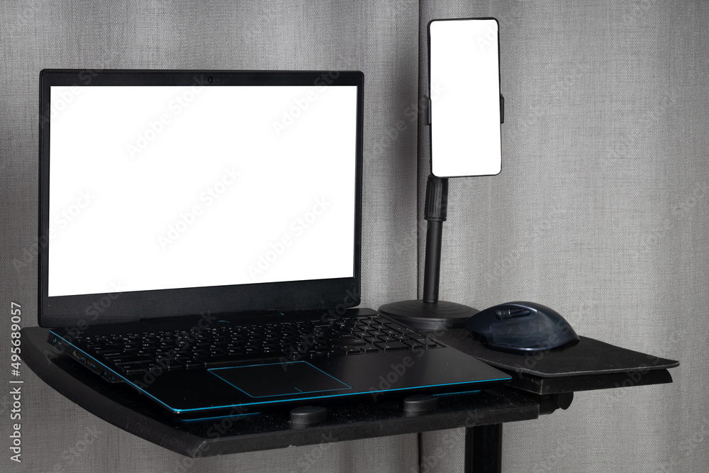 Poster laptop and a mouse on a special table with a smartphone on a tripod