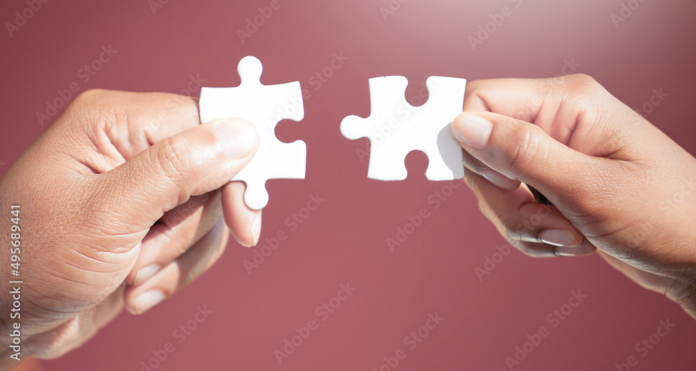 Poster solving the puzzle, piece by piece. cropped shot of two unrecognizable businesspeople fitting puzzle