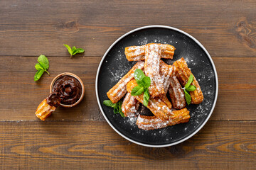 Churros fried pastry with chocolate sauce. Street food dessert