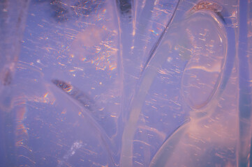 Fragment of an ice figure in the rays of the sun. Natural texture. Refraction, reflection and...