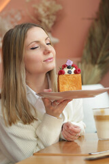 blond girl cube formed dessert with cream, raspberry, blueberry and marshmallow topping closeup...