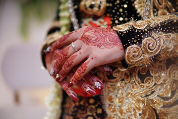 Beautiful Henna in the Hand of the Bride. mehendi young woman painting henna on hand. Detailed drawing of henna applied to women's hands