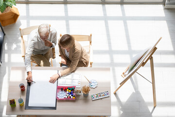 Ariel view couple artist meeting and brainstorming for work on the table