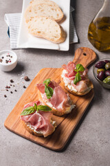 Bruschetta with prosciutto, basil, olives, spices and herbs. Appetizers.