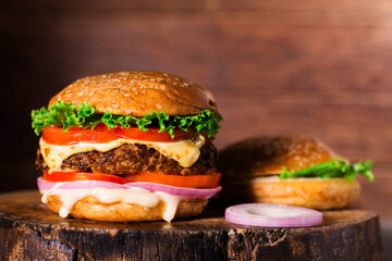 Close-up of delicious homemade burgers on a wooden table on a dark background beef hamburger freshly cooked delicious