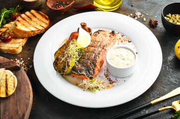 Baked salmon fillet with grilled vegetables on a plate. Top view.